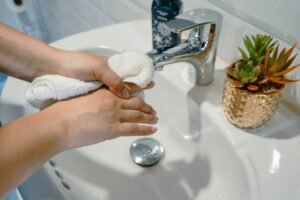 a person washing their hands in a sink